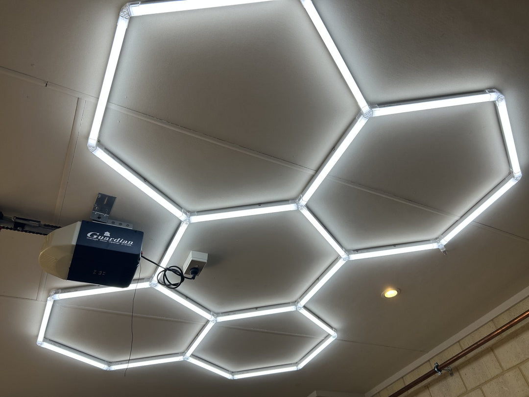 Hexagon LED grid on a white garage ceiling beside the garage door opener