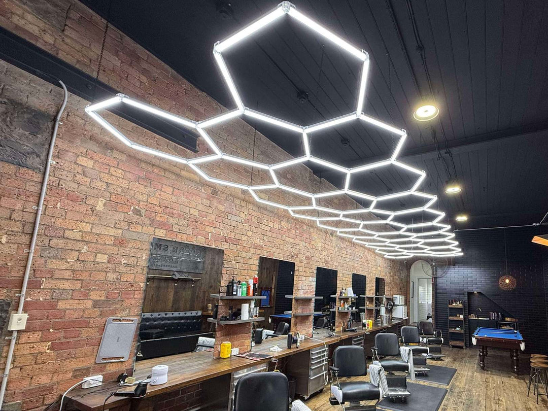 Hexagon LED grid lights over the mirror stations of a red brick barbershop
