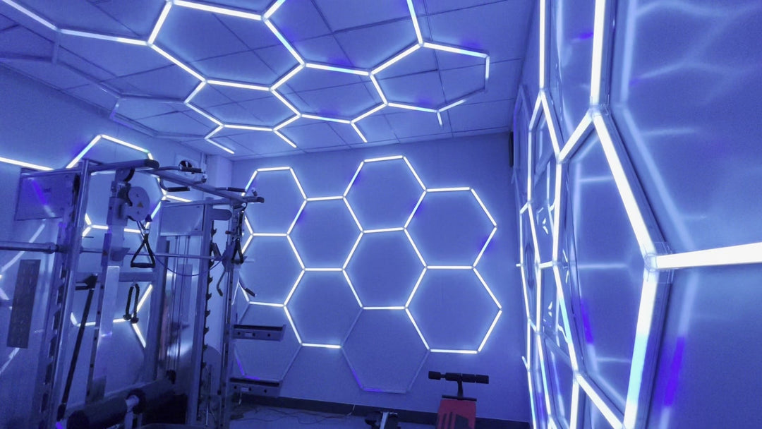 Gym walls and ceiling covered in RGB hexagon lights set to a cool blue tone, with a power rack in the corner