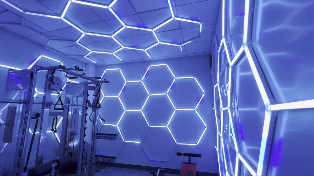Gym walls and ceiling covered in RGB hexagon lights set to a cool blue tone, with a power rack in the corner