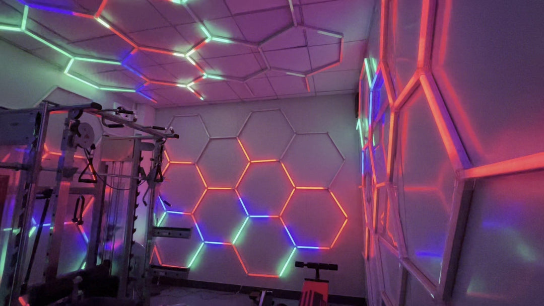 RGB hexagon lights on the walls and ceiling of a gym, showing red and blue segments around a power rack