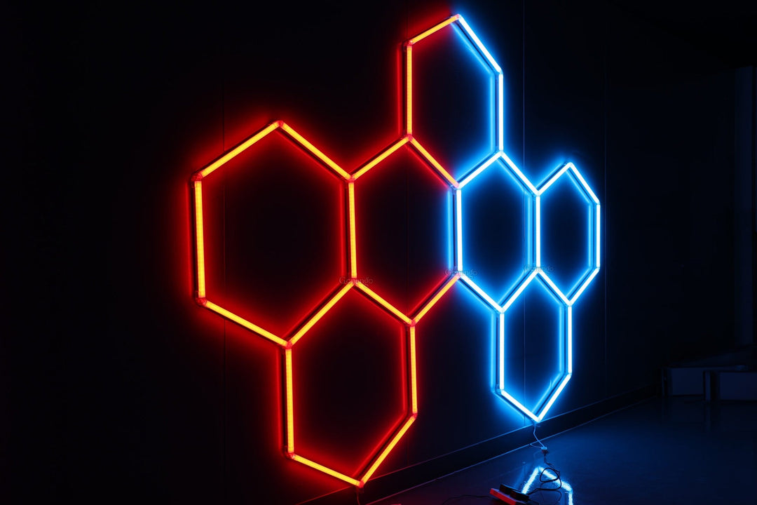 Two groups of RGB hexagon lights on a black wall, one glowing red and one glowing blue
